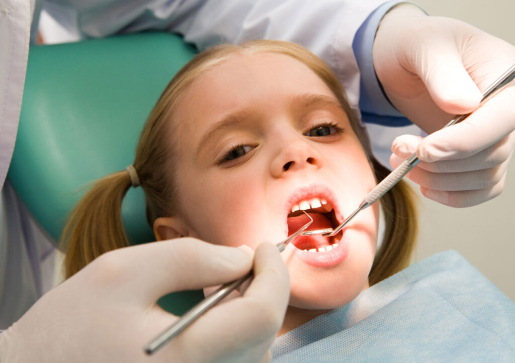 child at the dentist for regular cleaning to improve their smile
