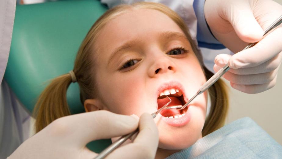 child at the dentist for regular cleaning to improve their smile