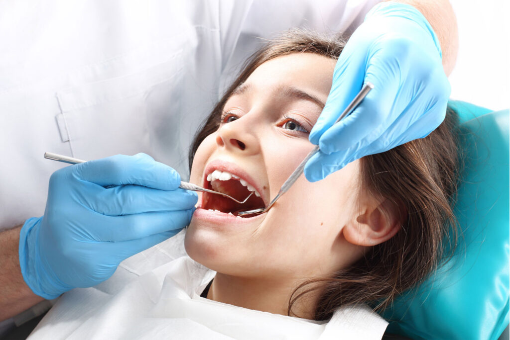 dentist applying dental sealants to improve a child’s smile
