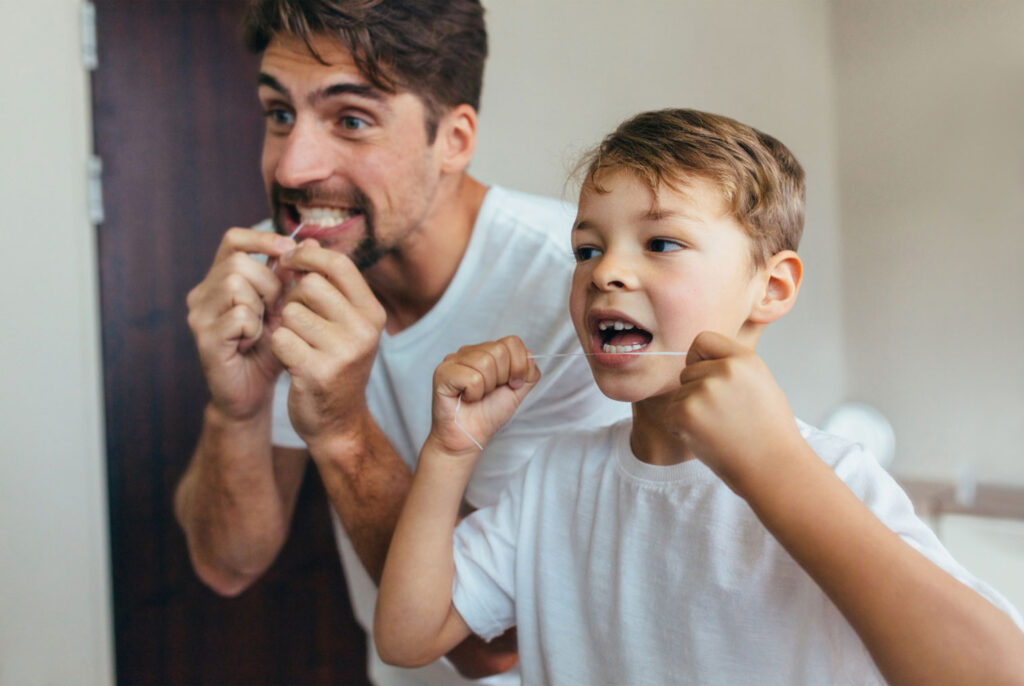 child flossing teeth after Halloween candy