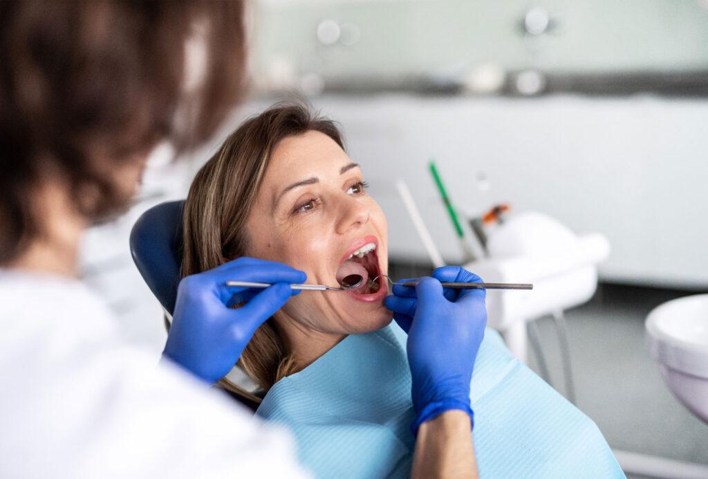 oral cancer screening at dental checkup dentist examining tongue and gums