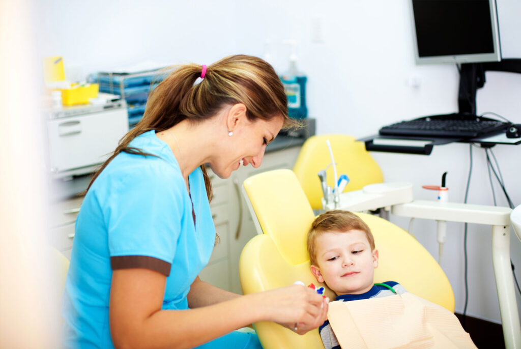 gentle pediatric dentist explaining checkup steps to child