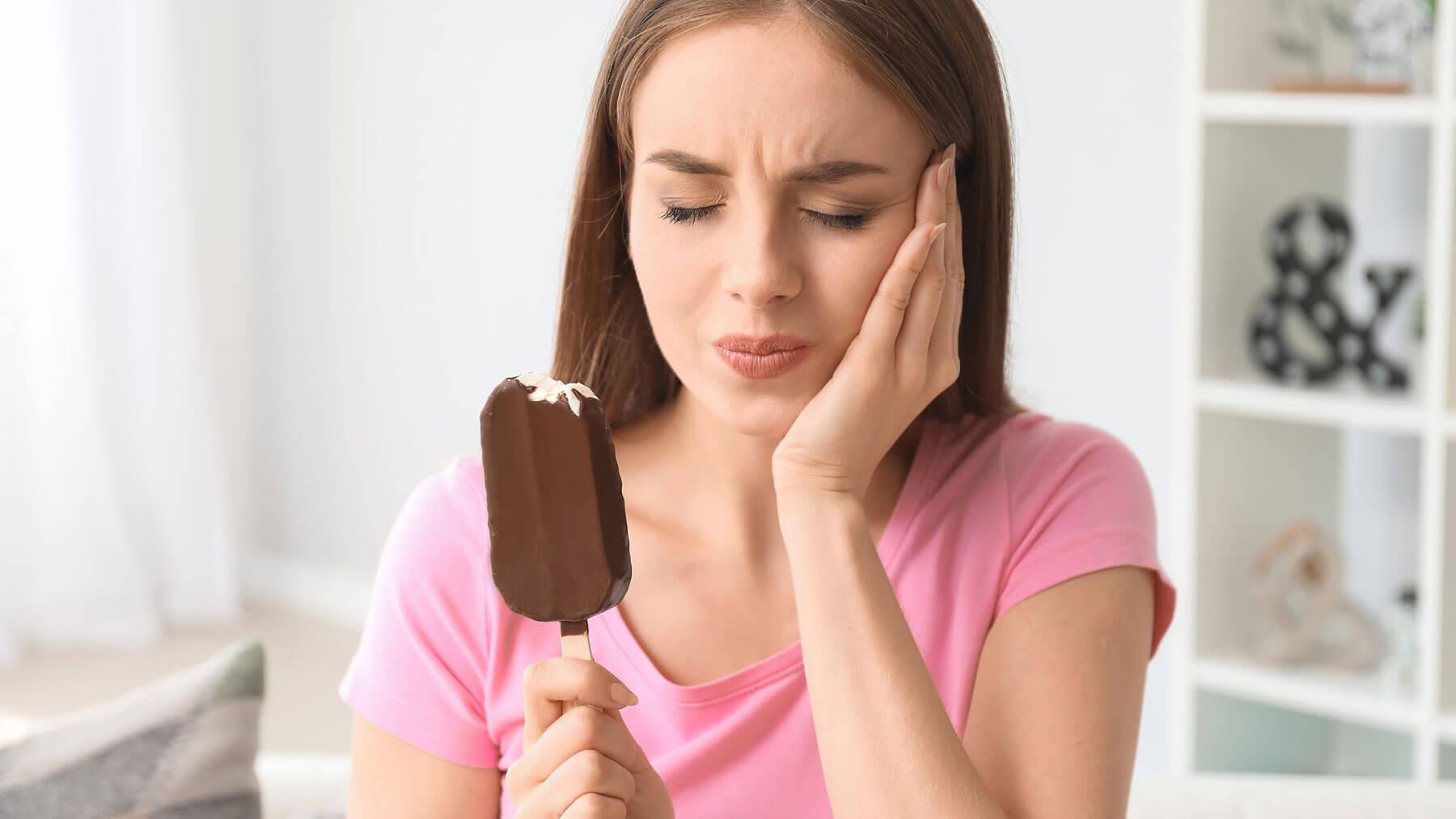 patient holding cheek with sudden tooth sensitivity pain