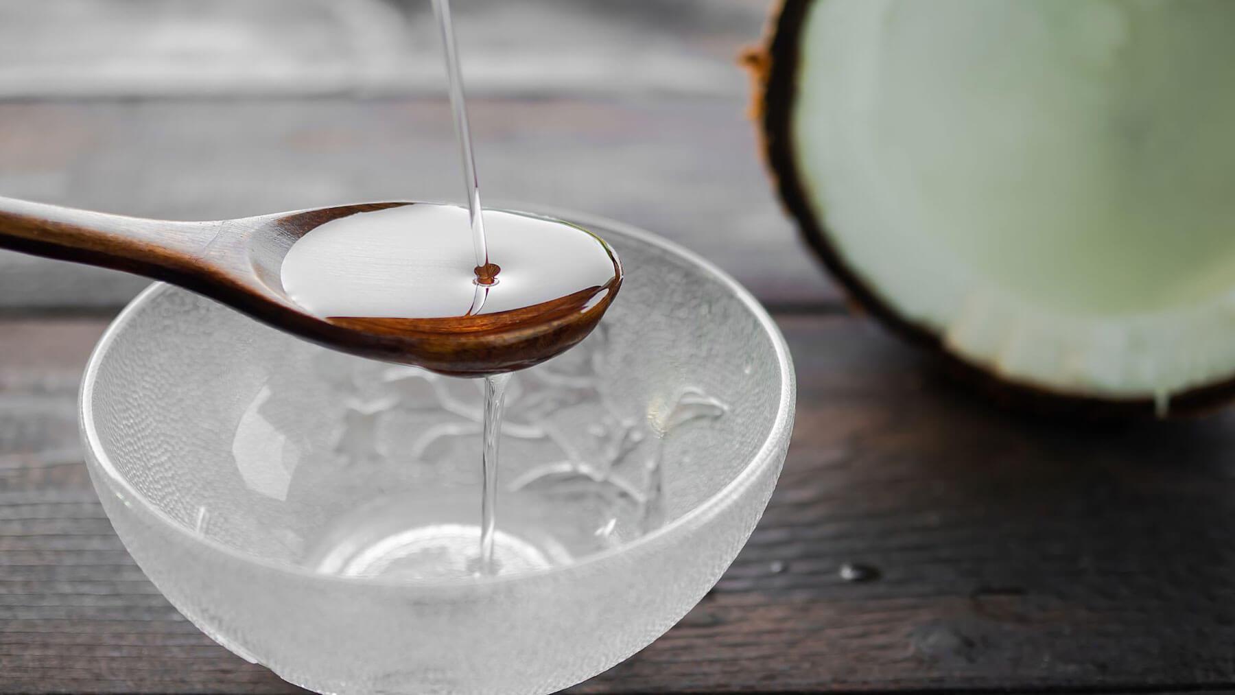 Person swishing coconut oil as part of an oil pulling routine